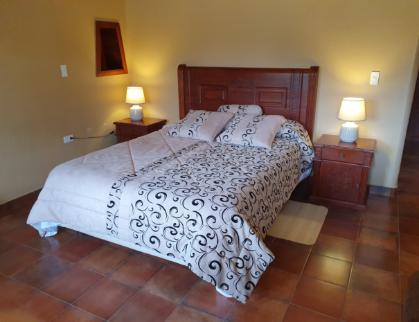 Cama matrimonial tallada a mano de la habitacion 1 de la Casa Verde